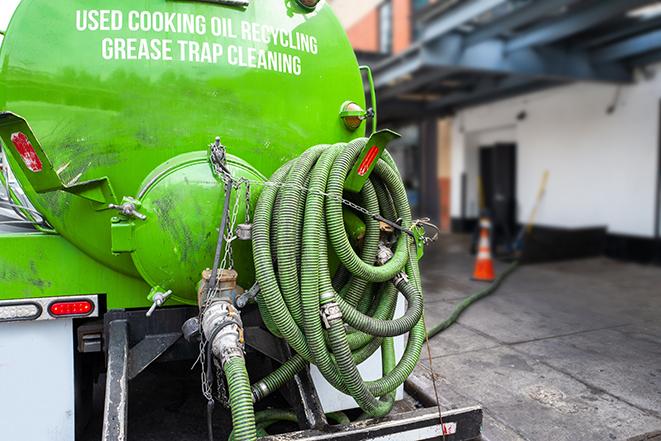 a grease trap being pumped by a sanitation technician in Shepherd, MI